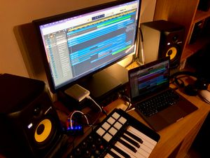 A view of Barry's recording setup, with monitors, laptop, midi keyboard and headphones